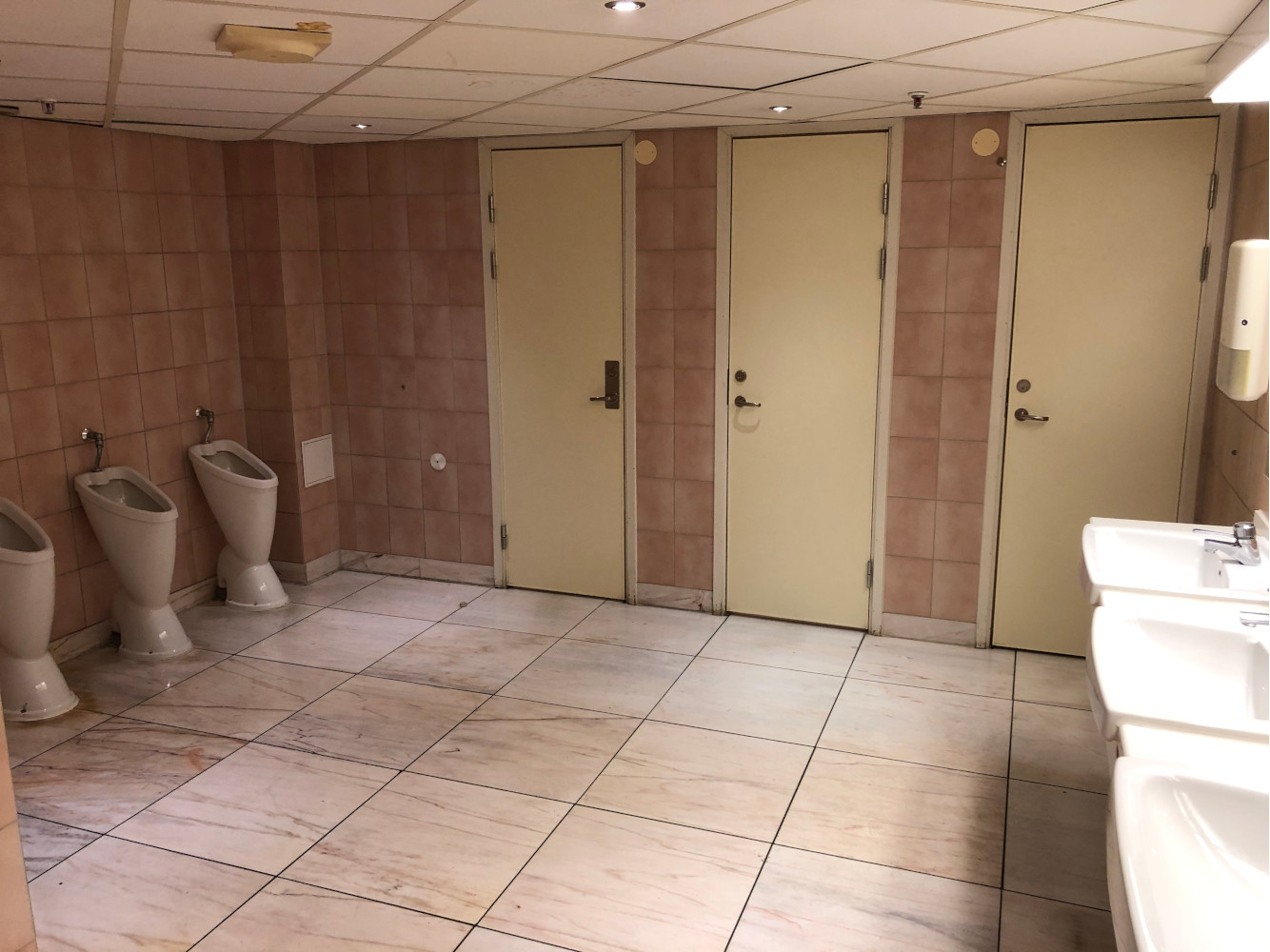Herrtoaletten en halvtrappa upp från entrén